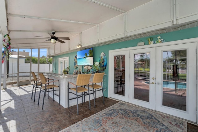 sunroom / solarium featuring french doors and ceiling fan