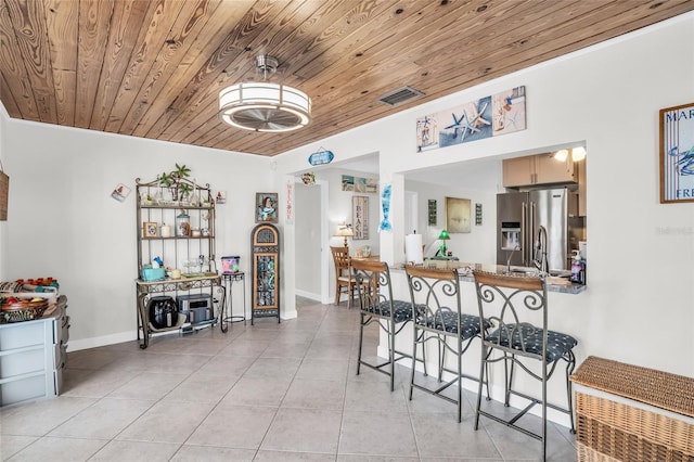 dining area with wooden ceiling and light tile patterned floors