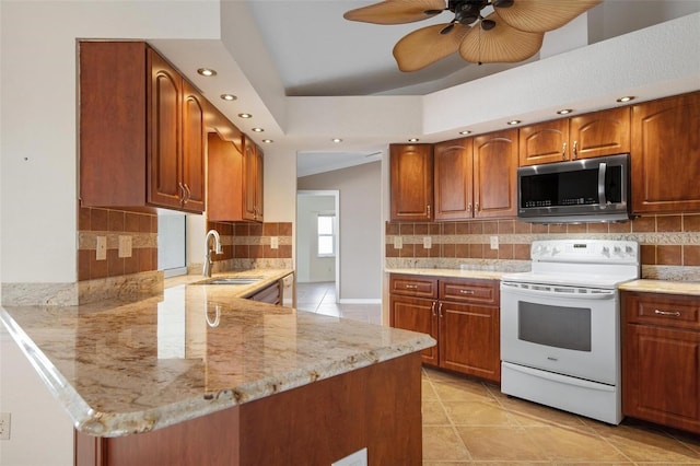 kitchen featuring sink, white range with electric cooktop, backsplash, light stone counters, and kitchen peninsula