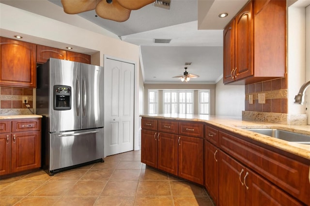 kitchen with ceiling fan, stainless steel fridge, sink, and decorative backsplash