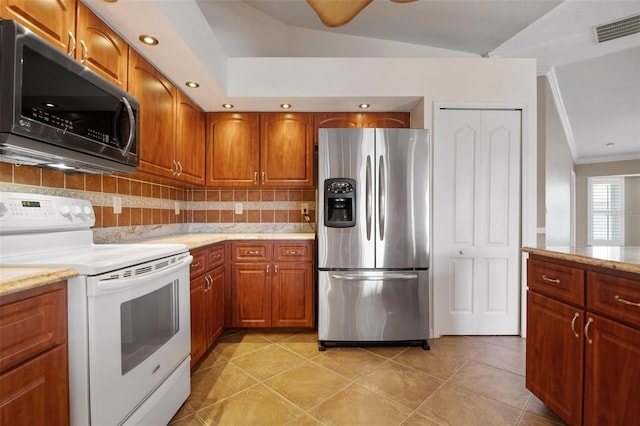 kitchen with light stone counters, light tile patterned floors, stainless steel fridge, electric stove, and decorative backsplash