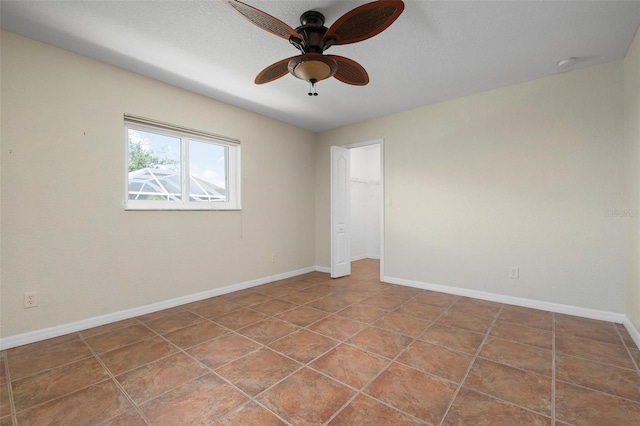 tiled spare room featuring ceiling fan