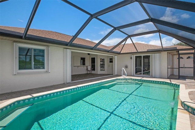 view of swimming pool featuring a patio area and glass enclosure