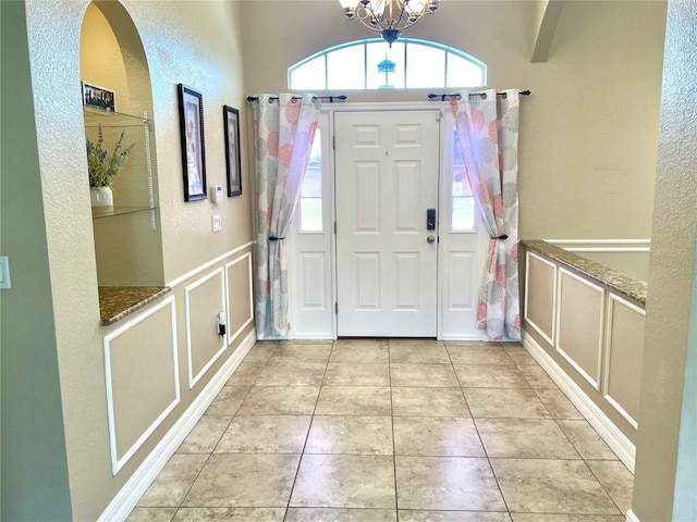 foyer with a notable chandelier and light tile patterned floors