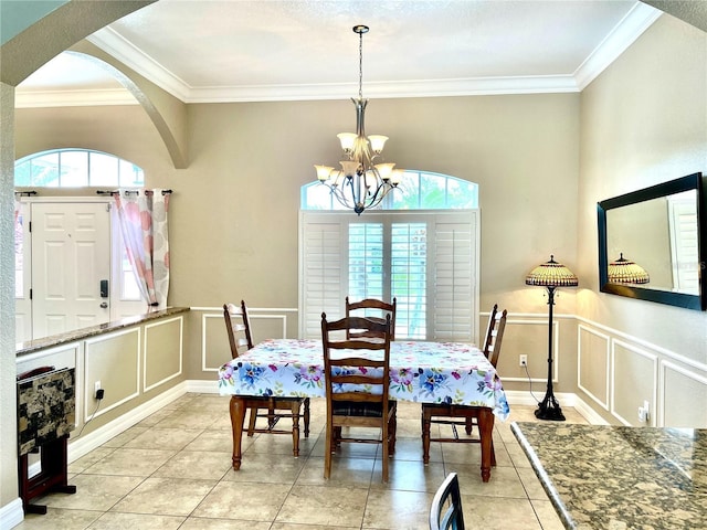 tiled dining room with ornamental molding and an inviting chandelier