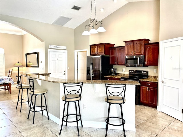 kitchen with a center island, appliances with stainless steel finishes, a breakfast bar, and light tile patterned floors