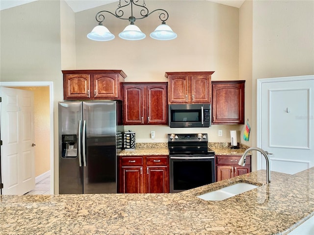 kitchen featuring pendant lighting, sink, light stone counters, and stainless steel appliances