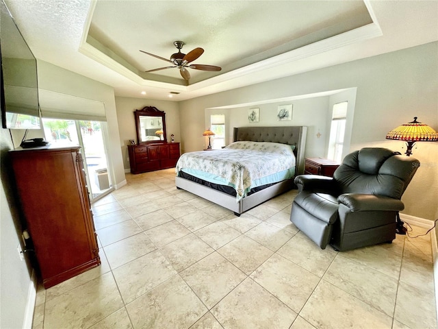 tiled bedroom with a raised ceiling and ceiling fan