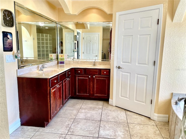 bathroom with vanity, tiled bath, and tile patterned flooring