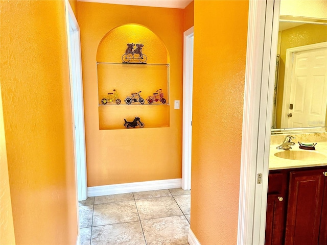 hall featuring sink, built in features, and light tile patterned floors