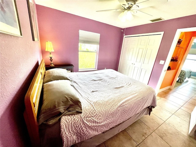 bedroom featuring ceiling fan, a closet, and light tile patterned floors