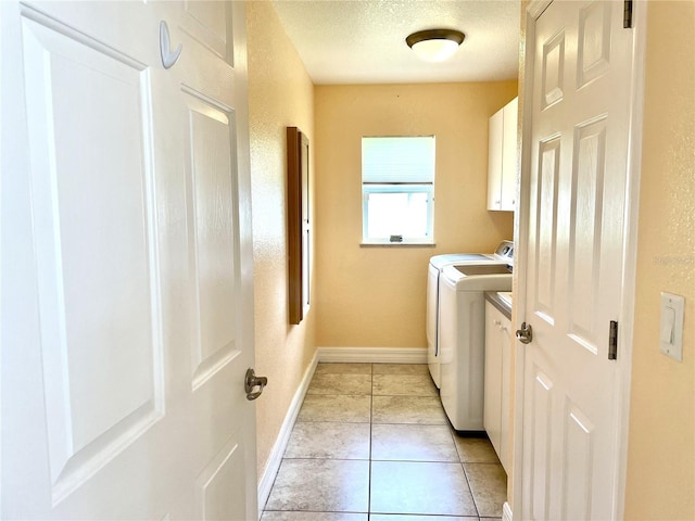 laundry room with independent washer and dryer, cabinets, a textured ceiling, and light tile patterned floors