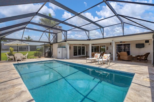 view of pool with ceiling fan, a patio, and a lanai