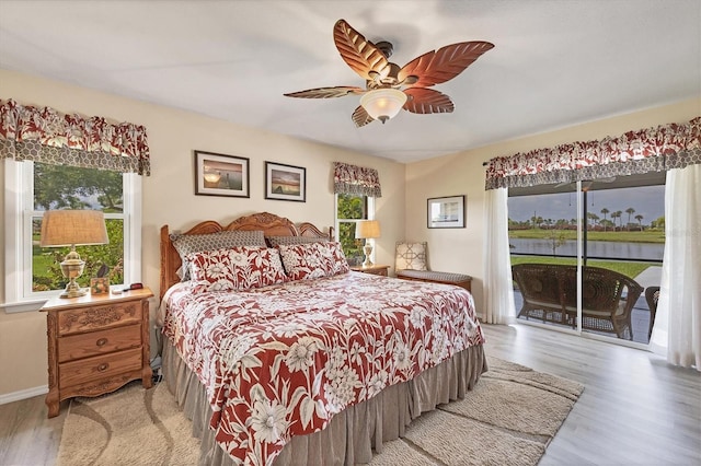 bedroom with hardwood / wood-style floors, access to outside, and ceiling fan