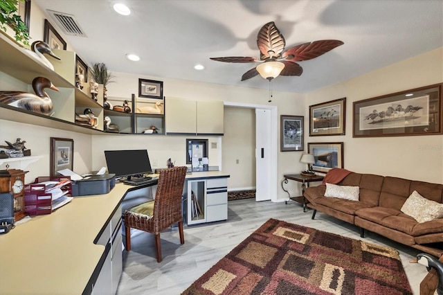 office area with light wood-type flooring, built in desk, and ceiling fan