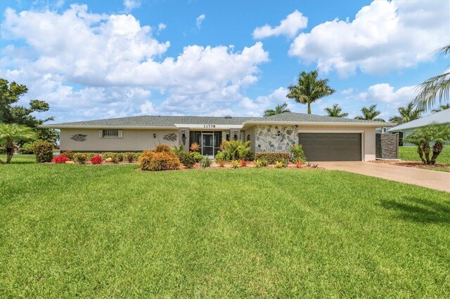 ranch-style home featuring a garage and a front lawn