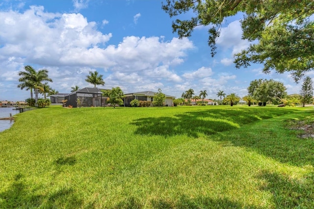 view of yard featuring a lanai and a water view