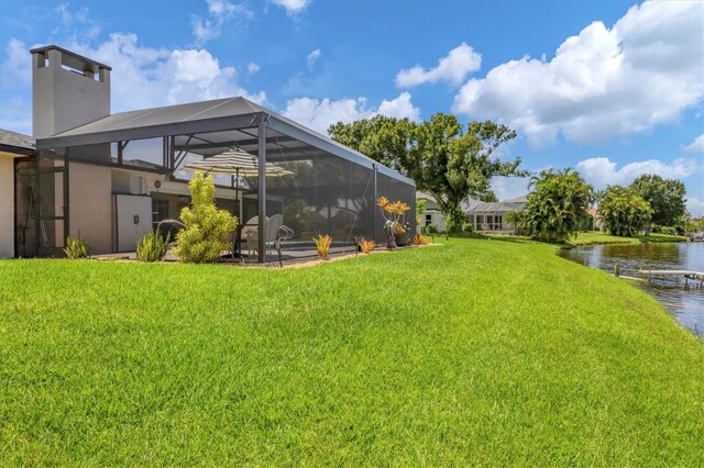 view of yard featuring a lanai and a water view