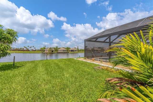 view of yard with a lanai and a water view