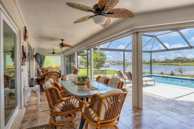 sunroom featuring a water view and a swimming pool