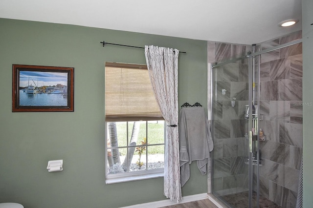 bathroom with hardwood / wood-style floors and an enclosed shower