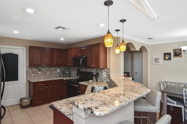 kitchen featuring electric stove, sink, kitchen peninsula, backsplash, and decorative light fixtures