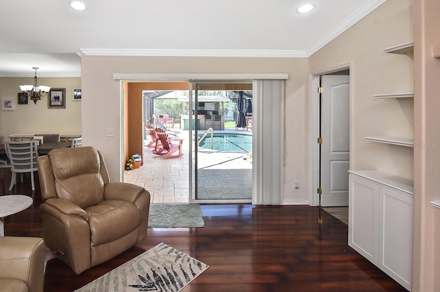 living room featuring dark hardwood / wood-style floors, crown molding, and an inviting chandelier