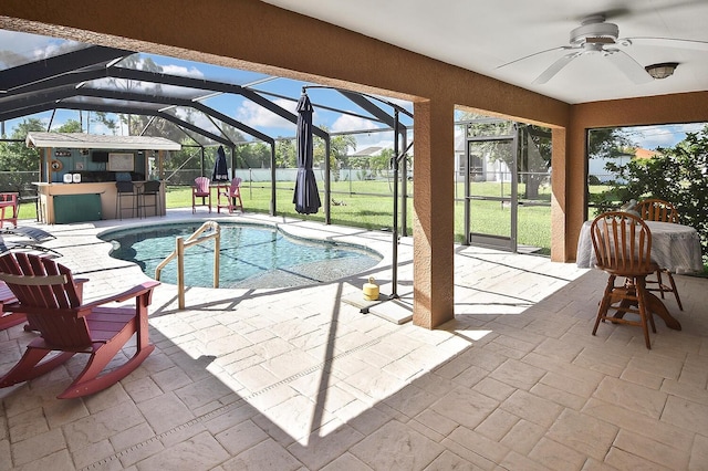 view of pool featuring a patio, ceiling fan, a lawn, and glass enclosure