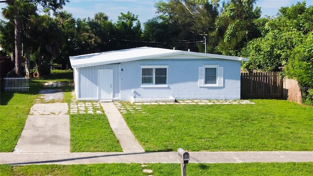 view of front of house featuring an outbuilding and a front yard