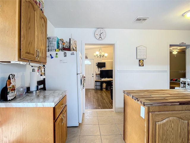 kitchen with light hardwood / wood-style floors, a notable chandelier, and white fridge