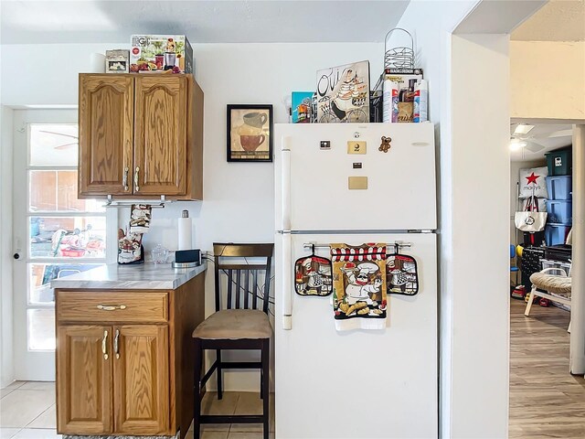 kitchen featuring white refrigerator, light hardwood / wood-style flooring, and ceiling fan