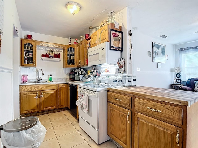 kitchen with decorative backsplash, light tile patterned flooring, white appliances, and sink