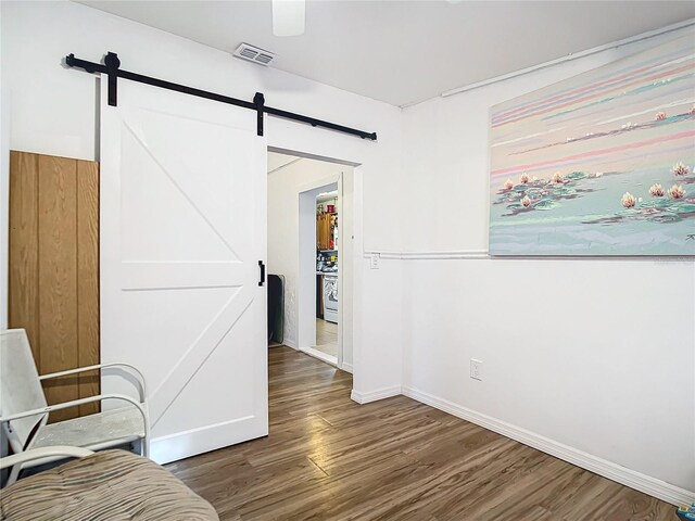 interior space with dark wood-type flooring and a barn door