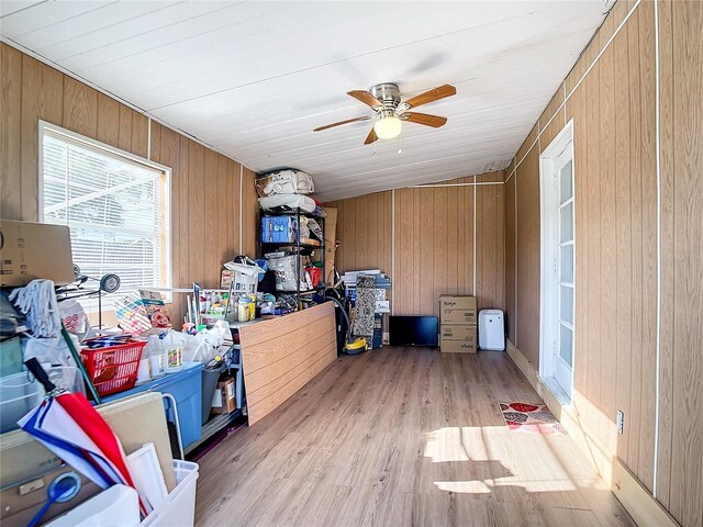 office space featuring light hardwood / wood-style floors, wood walls, and ceiling fan