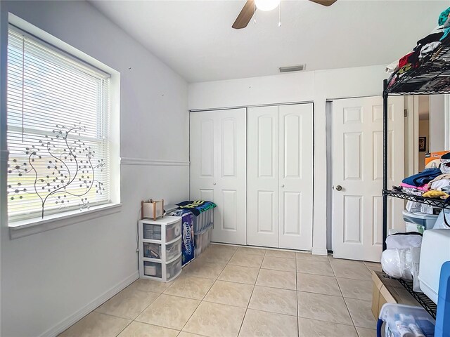 tiled bedroom with ceiling fan