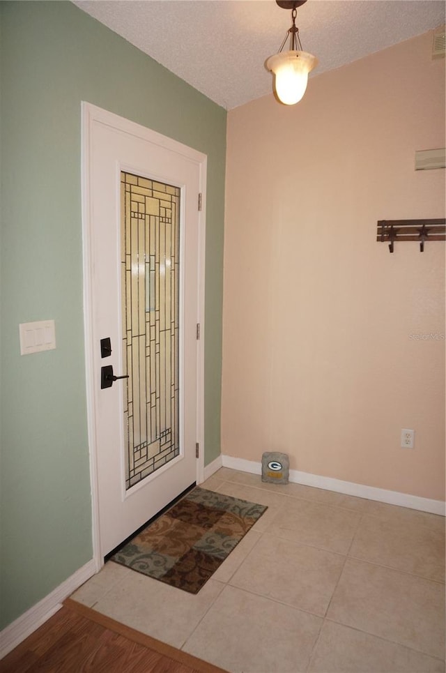 tiled foyer featuring a textured ceiling