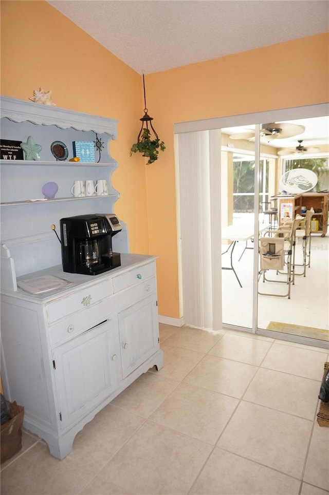 interior space featuring pendant lighting, light tile patterned flooring, and white cabinets