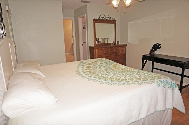 bedroom with ceiling fan, hardwood / wood-style flooring, and connected bathroom