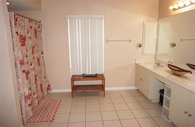 bathroom featuring tile patterned floors, lofted ceiling, and dual bowl vanity