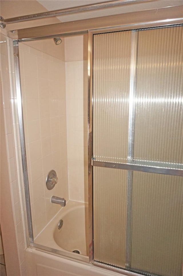 bathroom with bath / shower combo with glass door