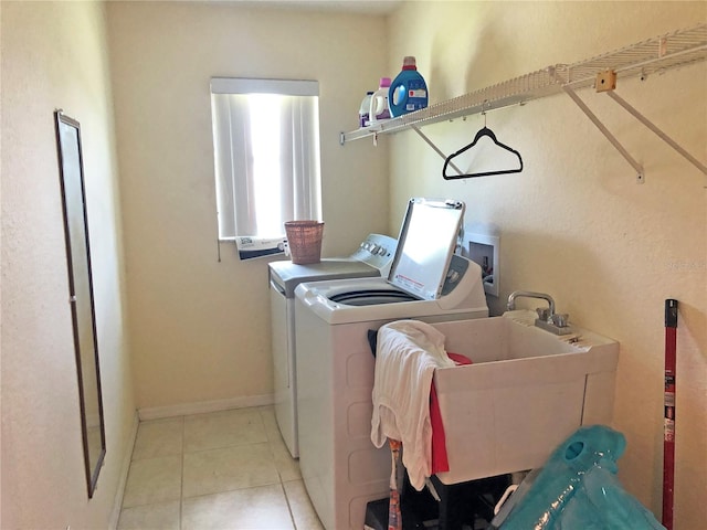 clothes washing area with sink, independent washer and dryer, and light tile patterned floors