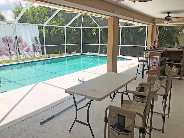 view of swimming pool with ceiling fan, a patio area, and a lanai