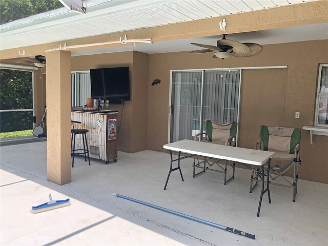 view of patio with exterior bar and ceiling fan