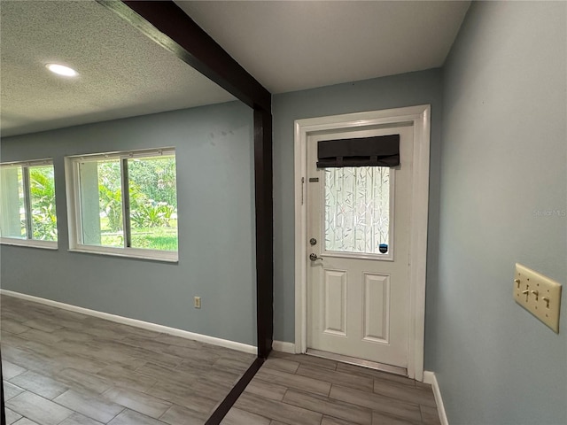 entrance foyer with beamed ceiling and a textured ceiling