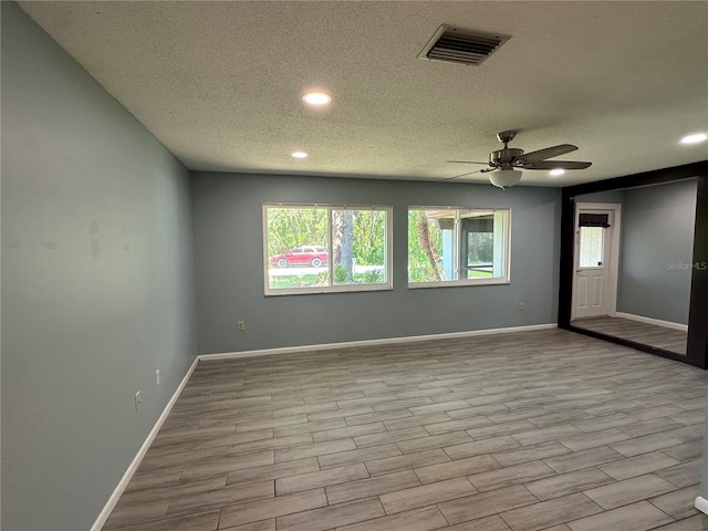 empty room featuring ceiling fan and a textured ceiling