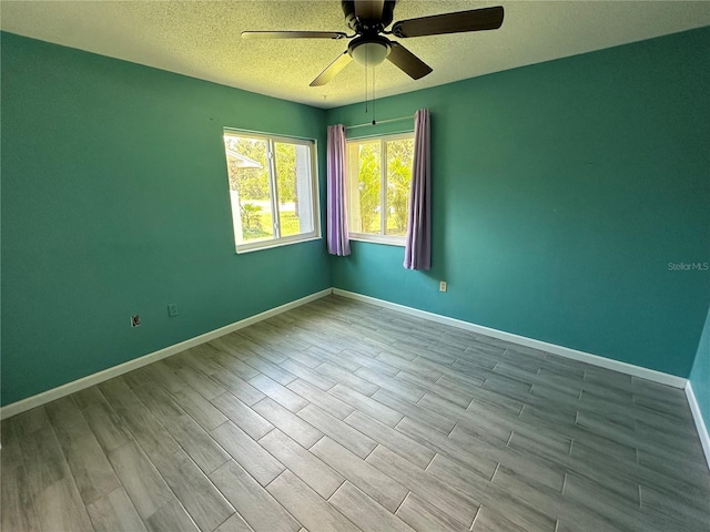 unfurnished room with ceiling fan and a textured ceiling