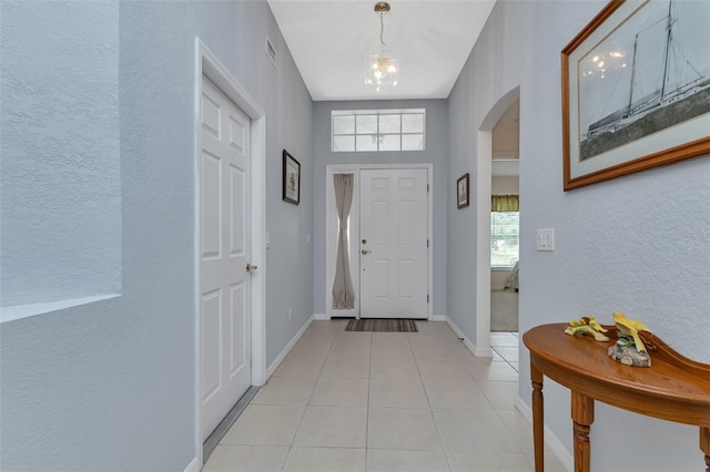 entryway with a notable chandelier and light tile patterned floors