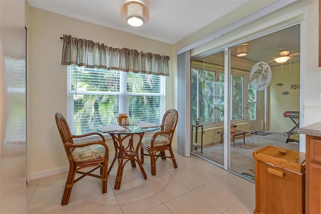 tiled dining area with ceiling fan and plenty of natural light