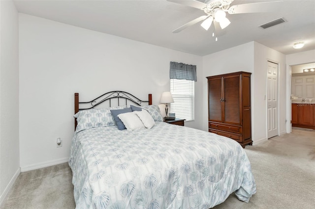 carpeted bedroom with connected bathroom and ceiling fan