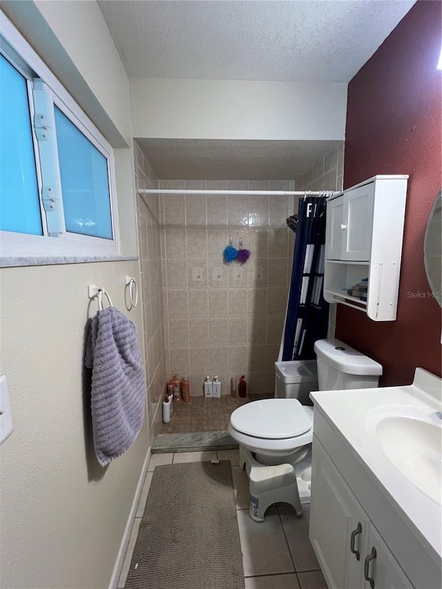 bathroom featuring tile patterned floors, toilet, a shower with curtain, a textured ceiling, and vanity